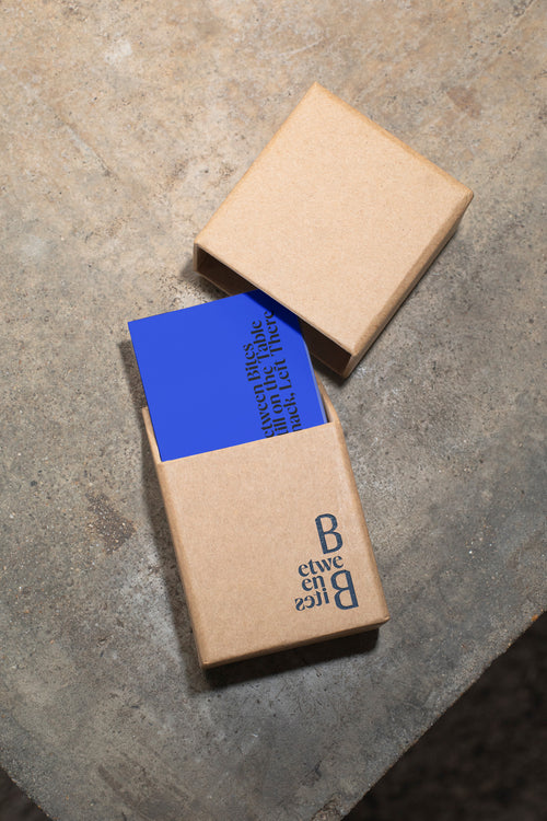 Business card mockup in packaging on a raw concrete table.
