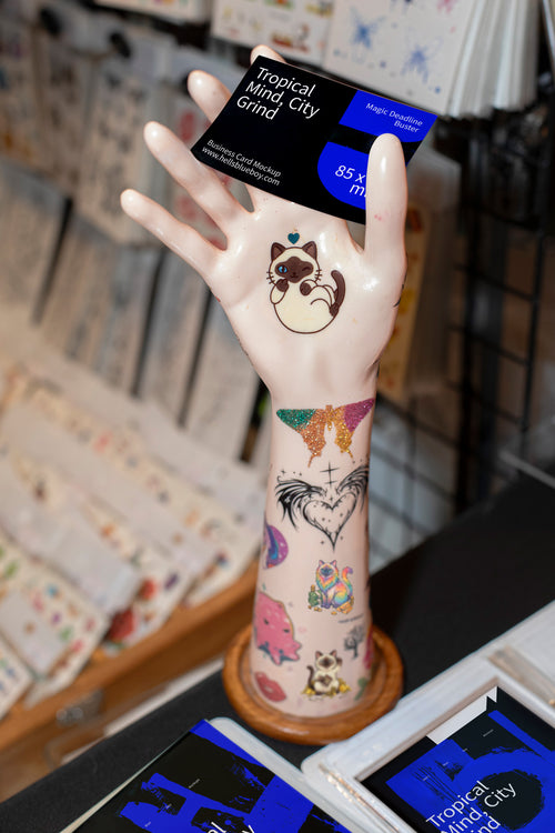 Business card mockup with a mannequin display hand and market stall background