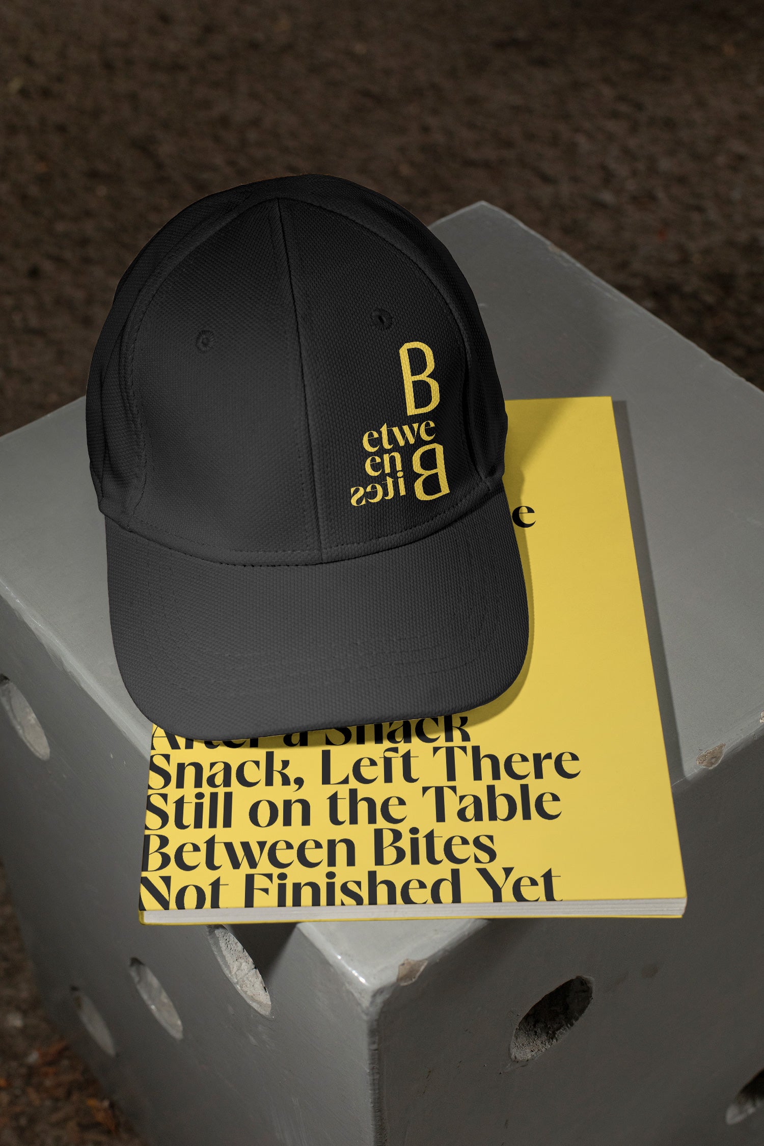 Two mockups in one featuring a cap and softcover magazine on a concrete chair.