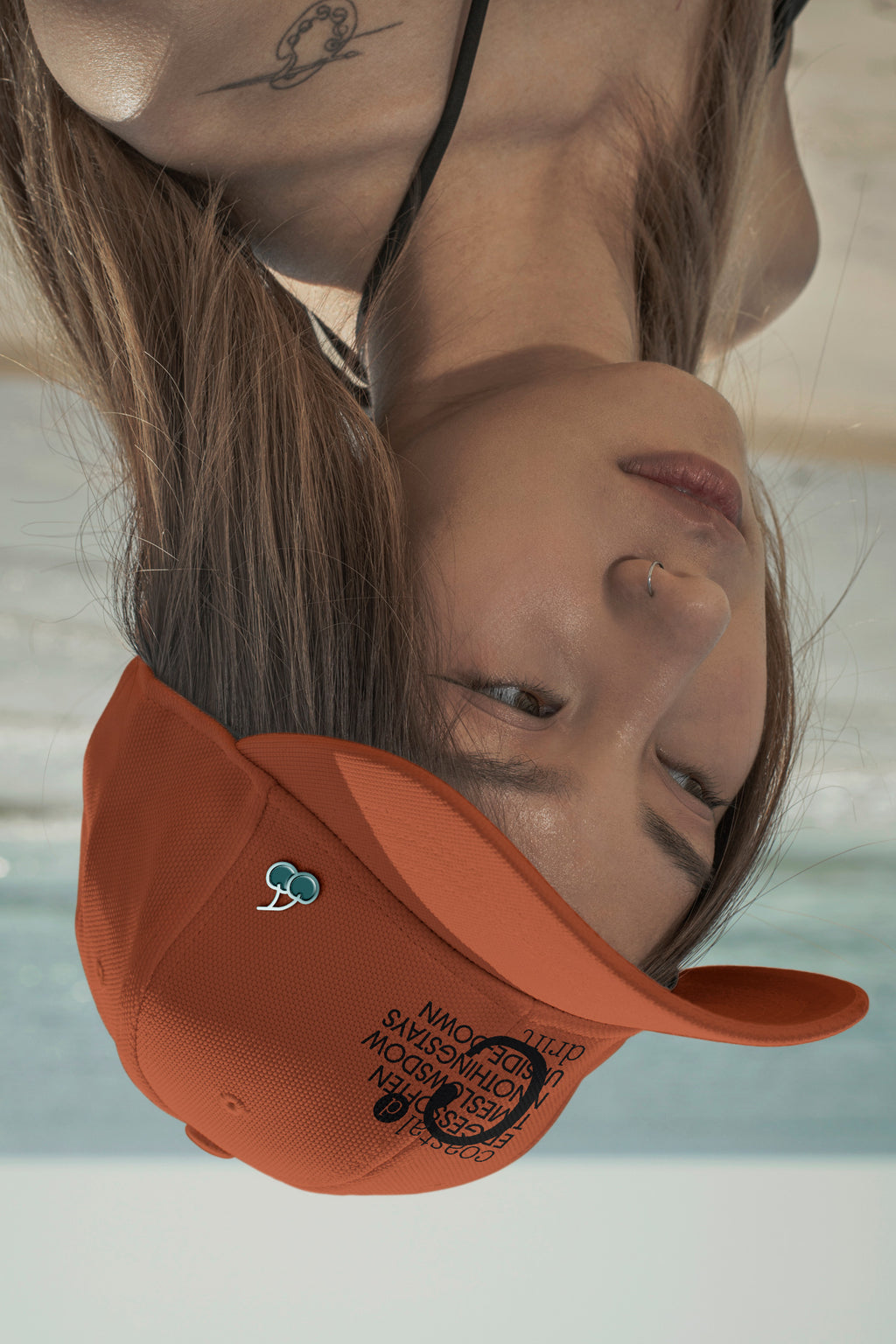 Upside-down cap mockup at the beach with a customizable pin