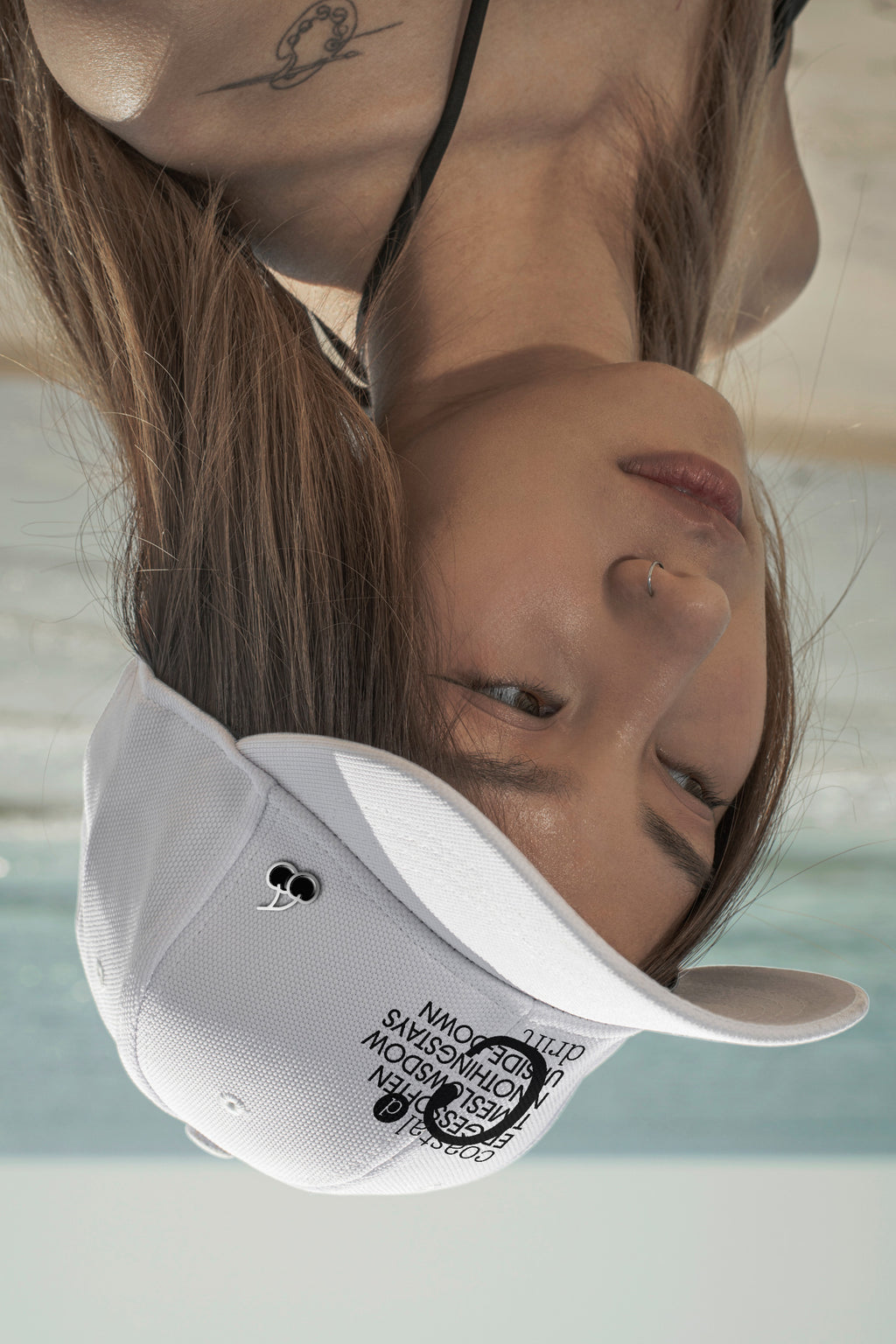 Upside-down cap mockup at the beach with a customizable pin