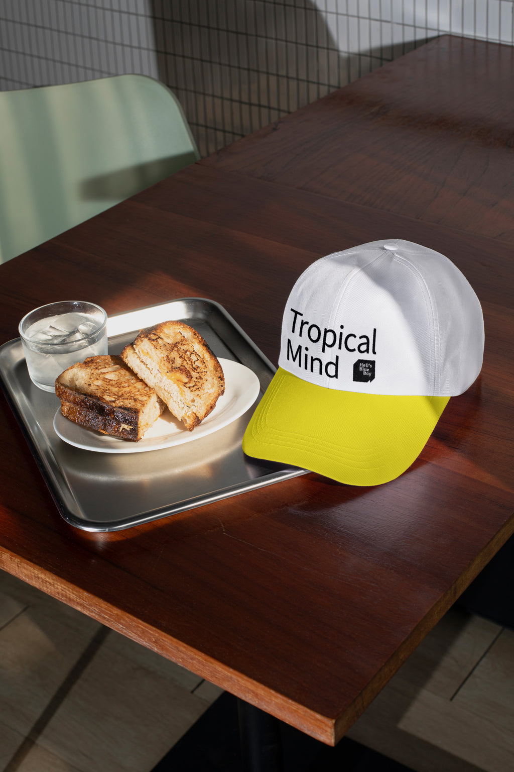 Baseball cap mockup placed on a café table with sandwich.