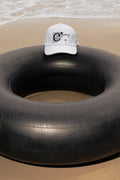 Cap mockup placed on a traditional Thai inner tube float at the beach in Hua Hin, Thailand. Choose between a realistic embroidery effect or a clean graphic application.