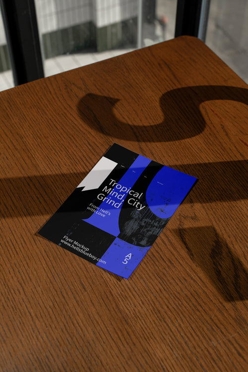 Flyer mockup on a dark wood surface with dramatic shadows.
