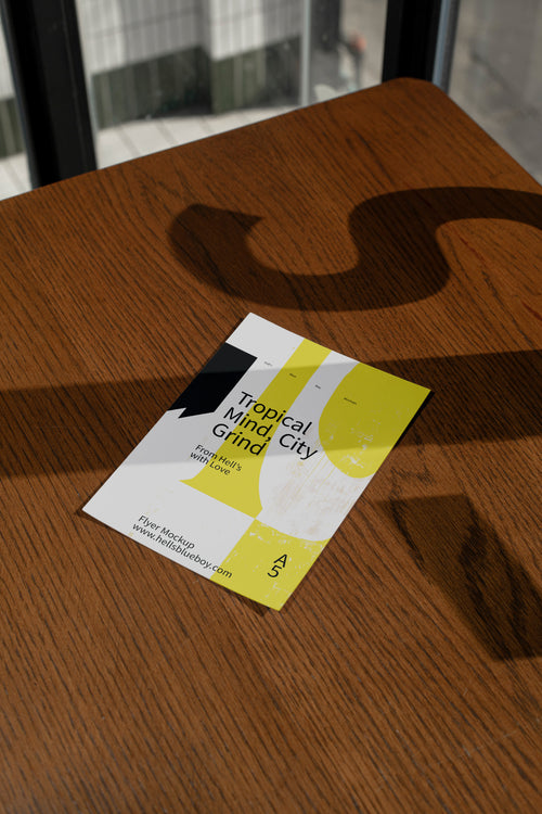 Flyer mockup on a dark wood surface with dramatic shadows.