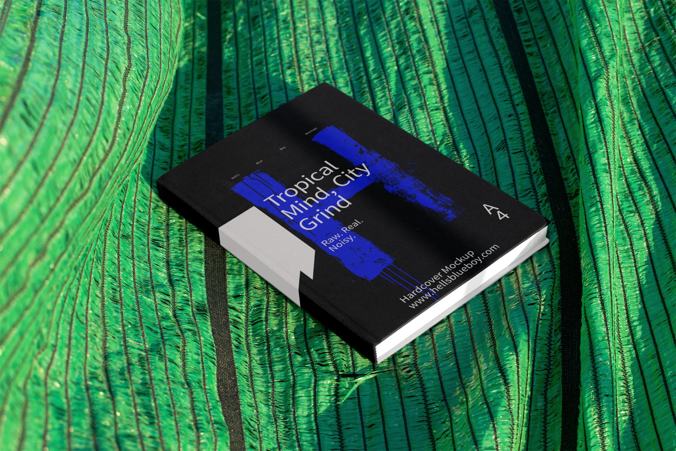 Hardcover book cover mockup set against a green mesh plastic background used for outdoor shading in Thailand. Ideal for editorial and print design.