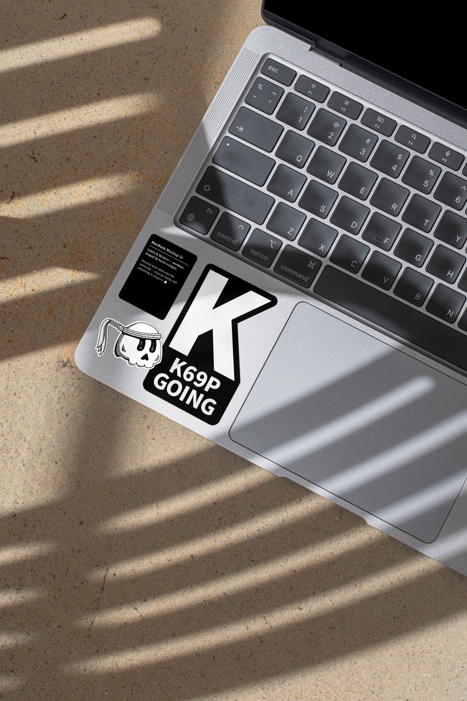 MacBook mockup shaped by harsh sunlight, featuring labels and stickers placed directly on the laptop.