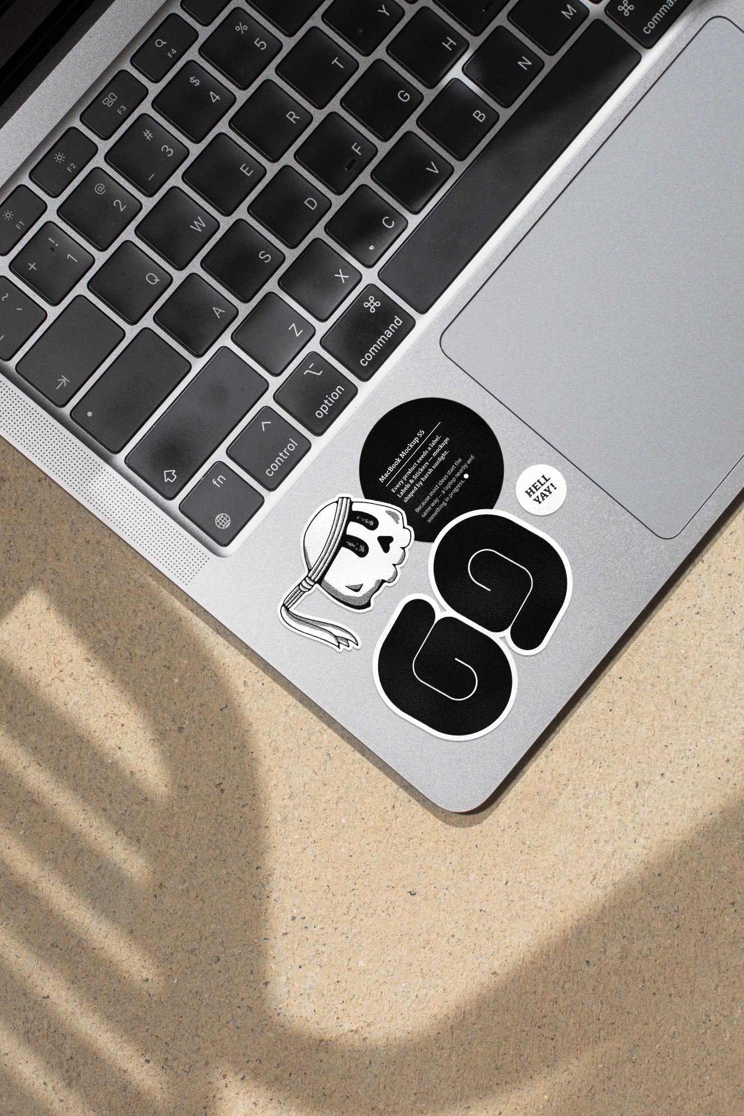 MacBook mockup shaped by harsh sunlight, featuring labels and stickers placed directly on the laptop.