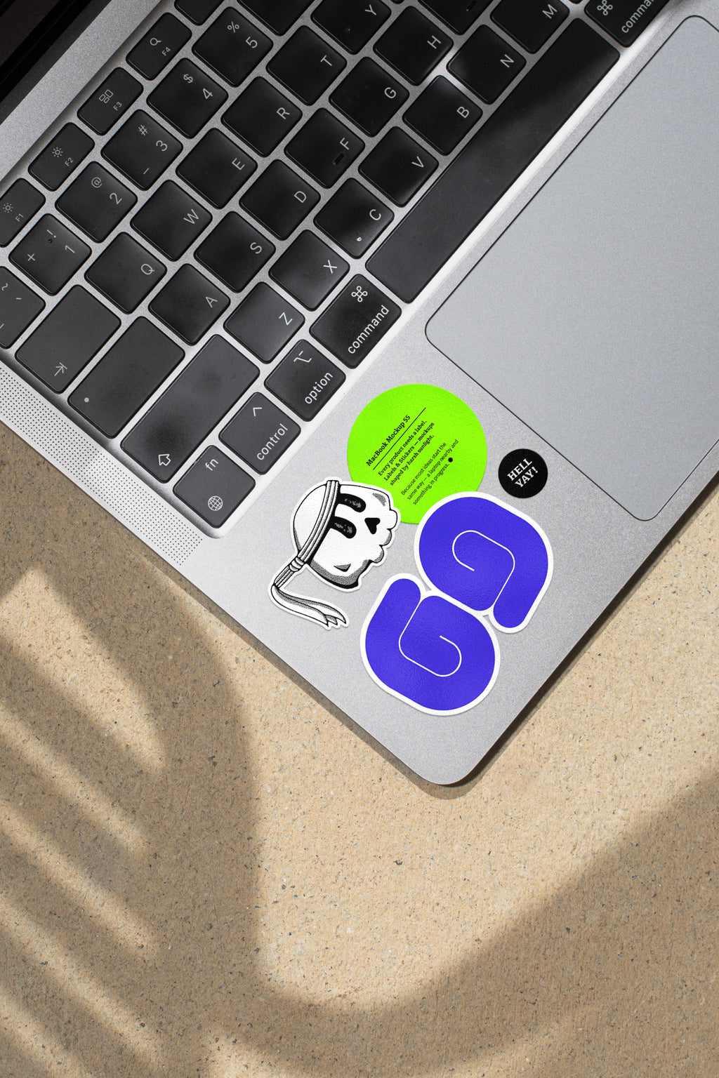 MacBook mockup shaped by harsh sunlight, featuring labels and stickers placed directly on the laptop.