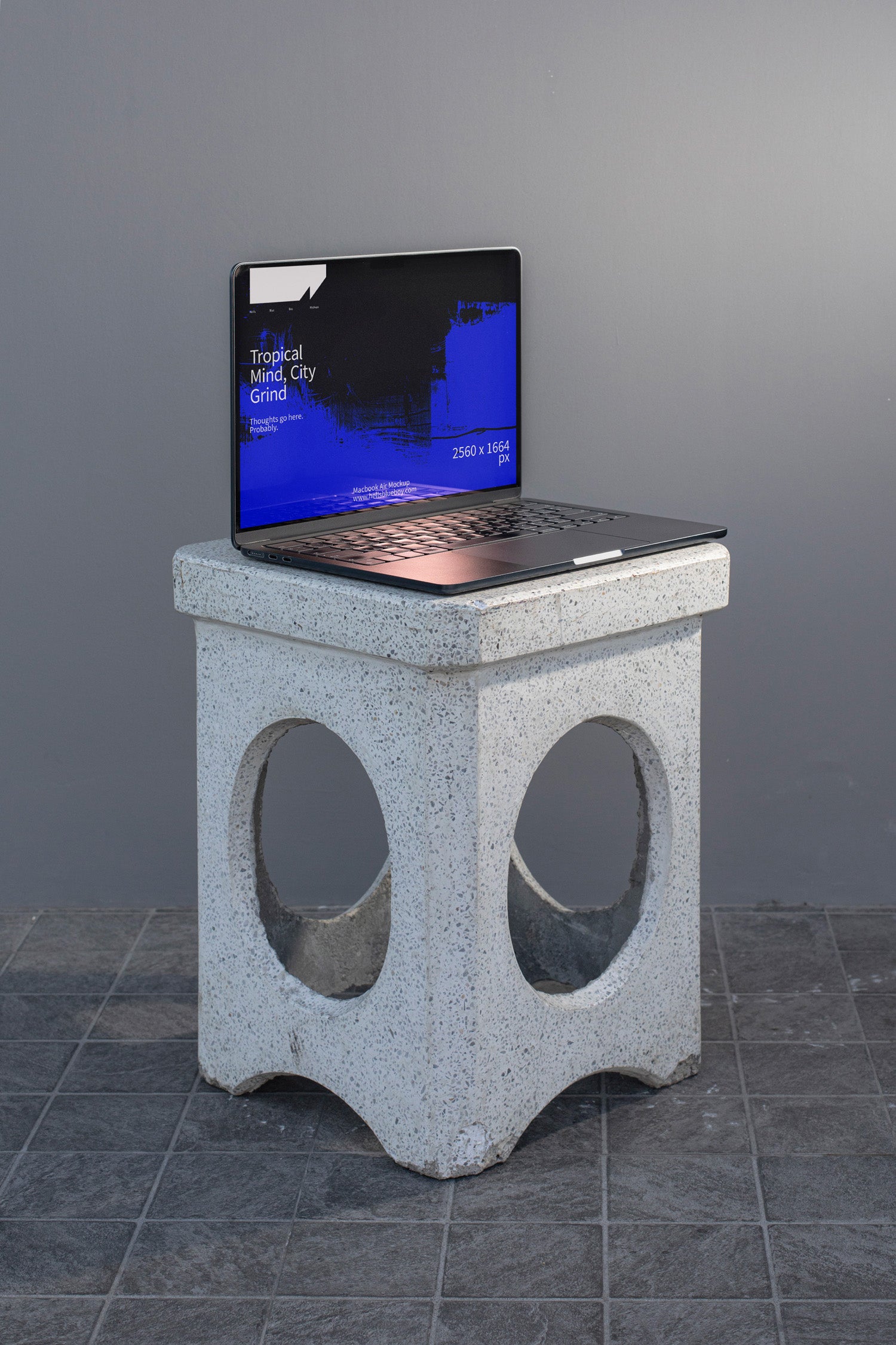 Photorealistic MacBook mockup placed on a concrete bench.