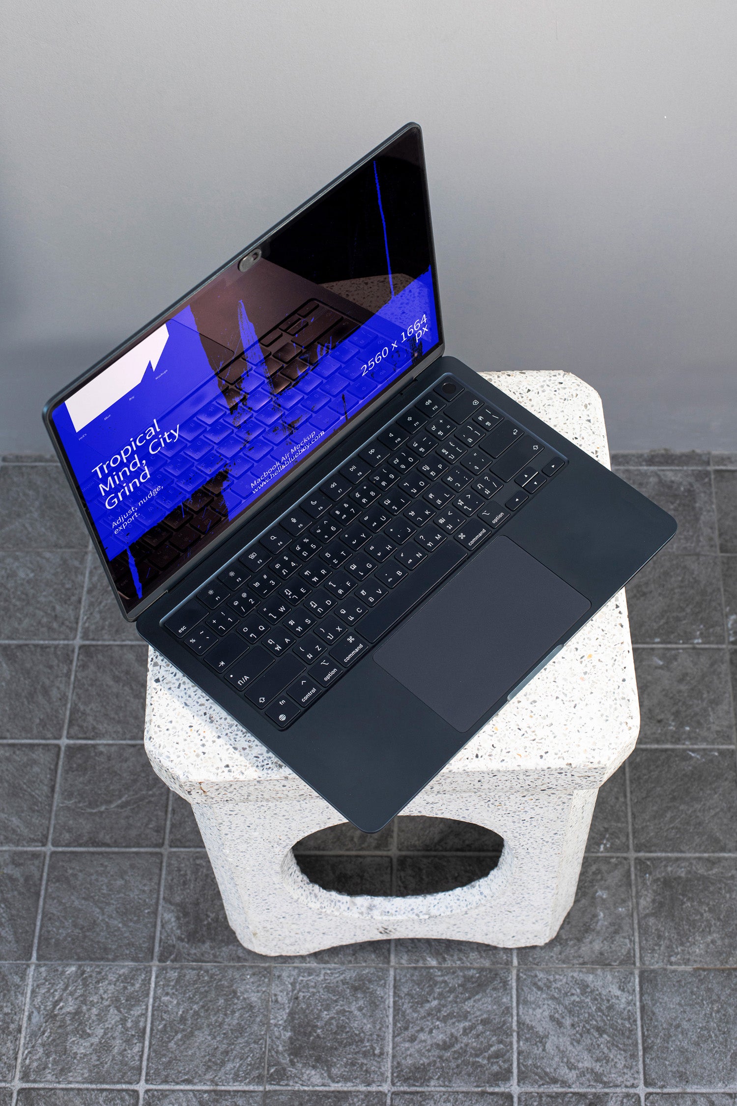 MacBook mockup placed on a concrete bench.