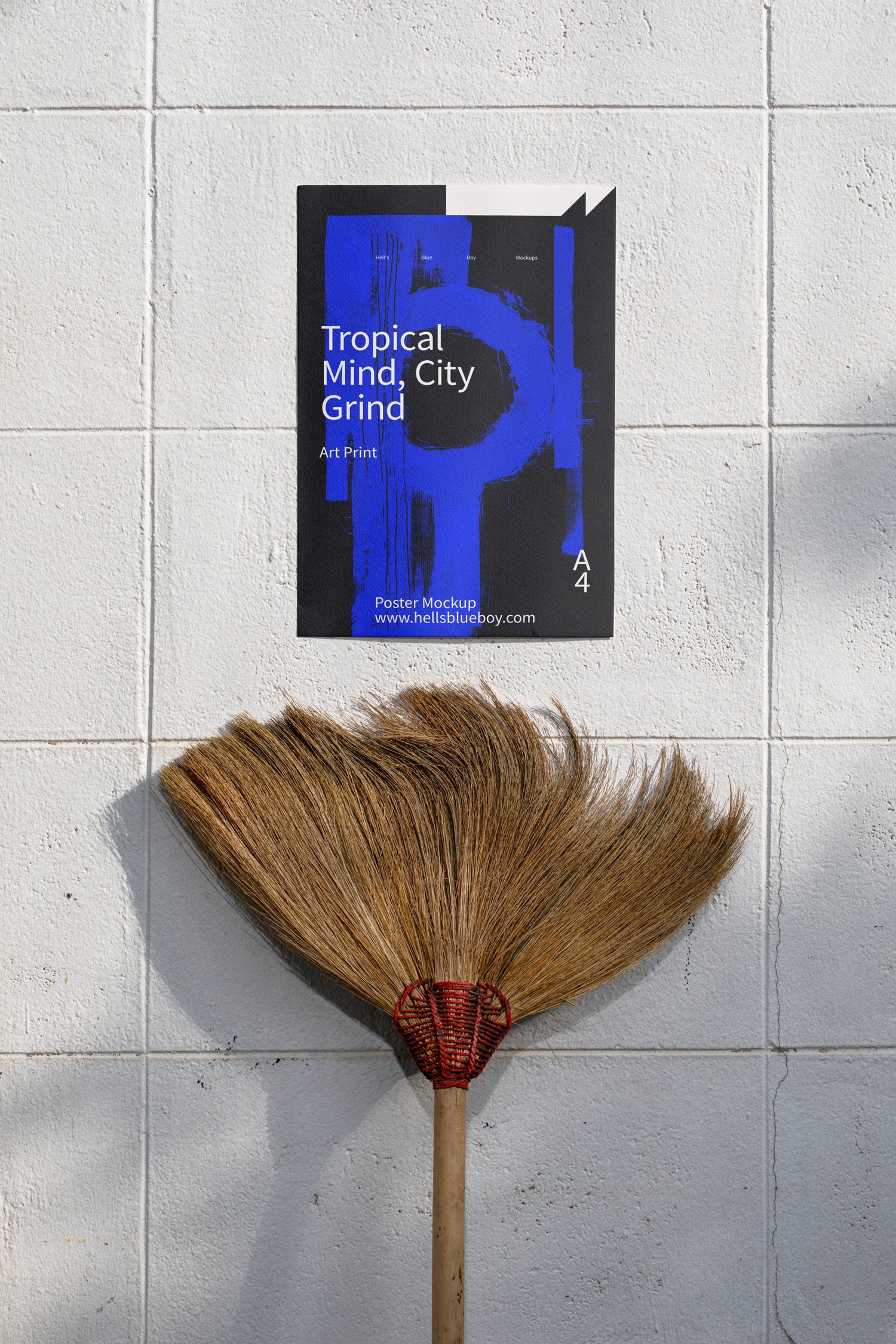 Poster mockup displayed on a white brick wall with a moustache-shaped broom below.