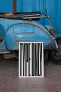 Poster mockup leaning against a vintage blue Vespa.