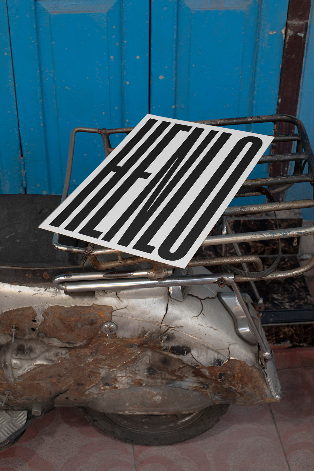 Poster mockup lying on the backpack of a vintage silver Vespa.