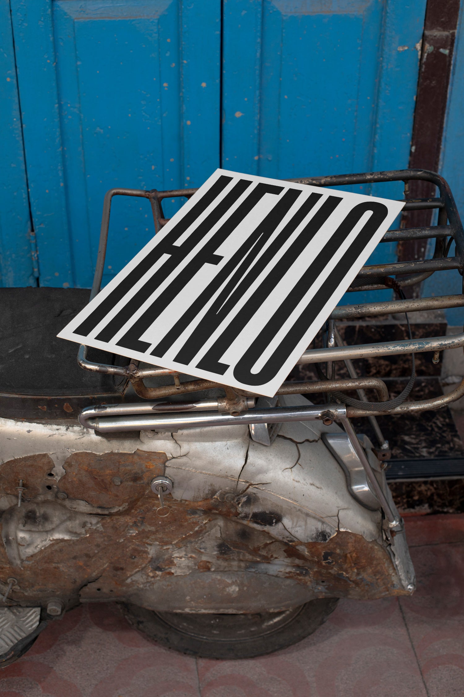 Poster mockup lying on the backpack of a vintage silver Vespa.
