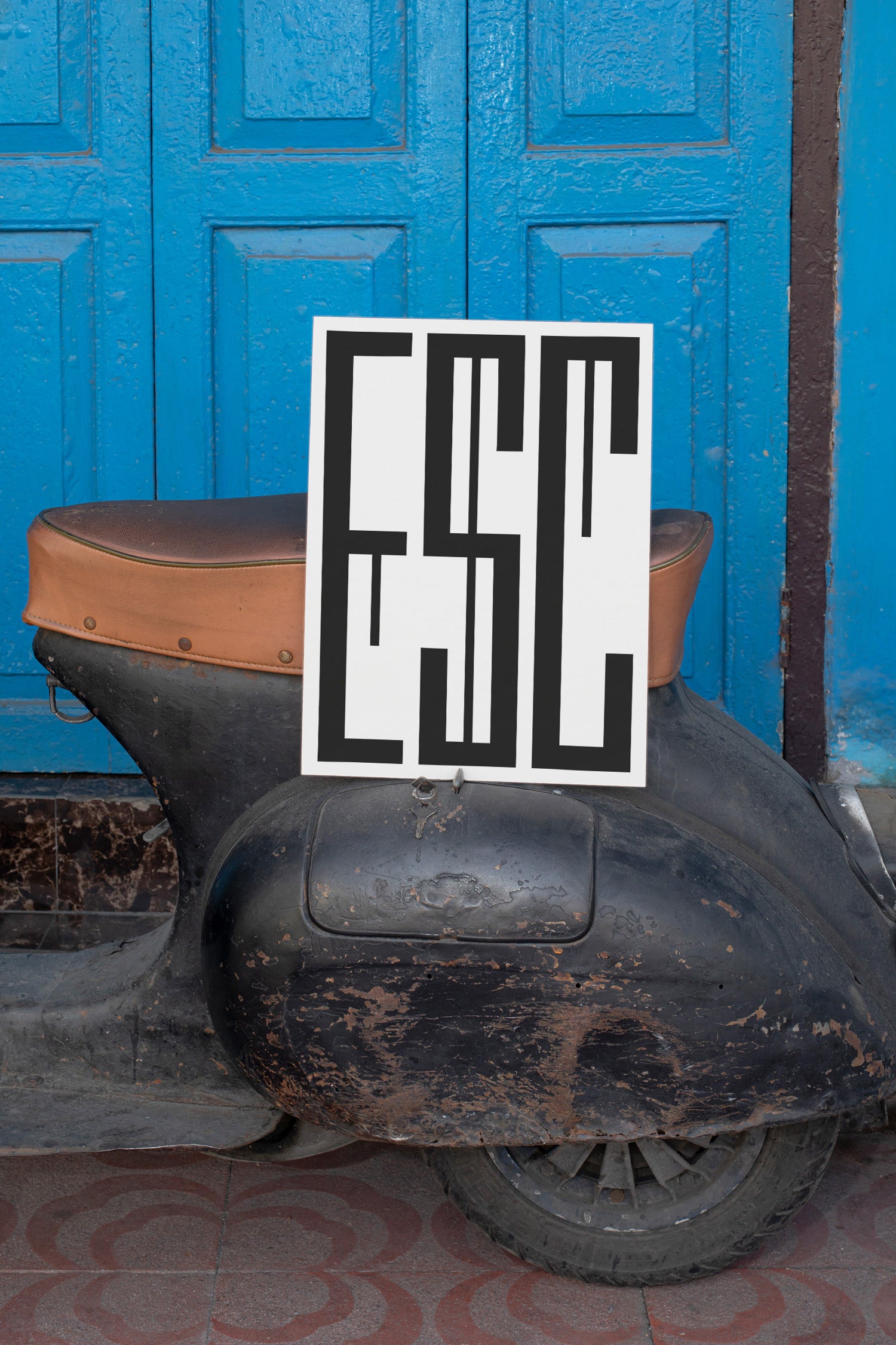 Poster mockup leaning against a vintage black Vespa.