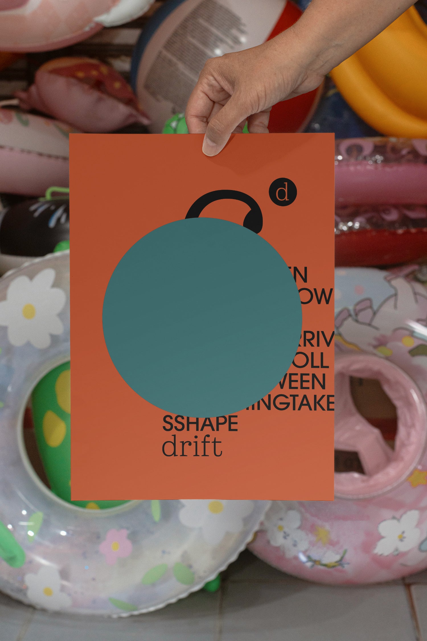 Poster mockup held by hand against a backdrop of several colorful plastic swim rings. Built for showcasing posters, editorial layouts, typography, branding, and print concepts.