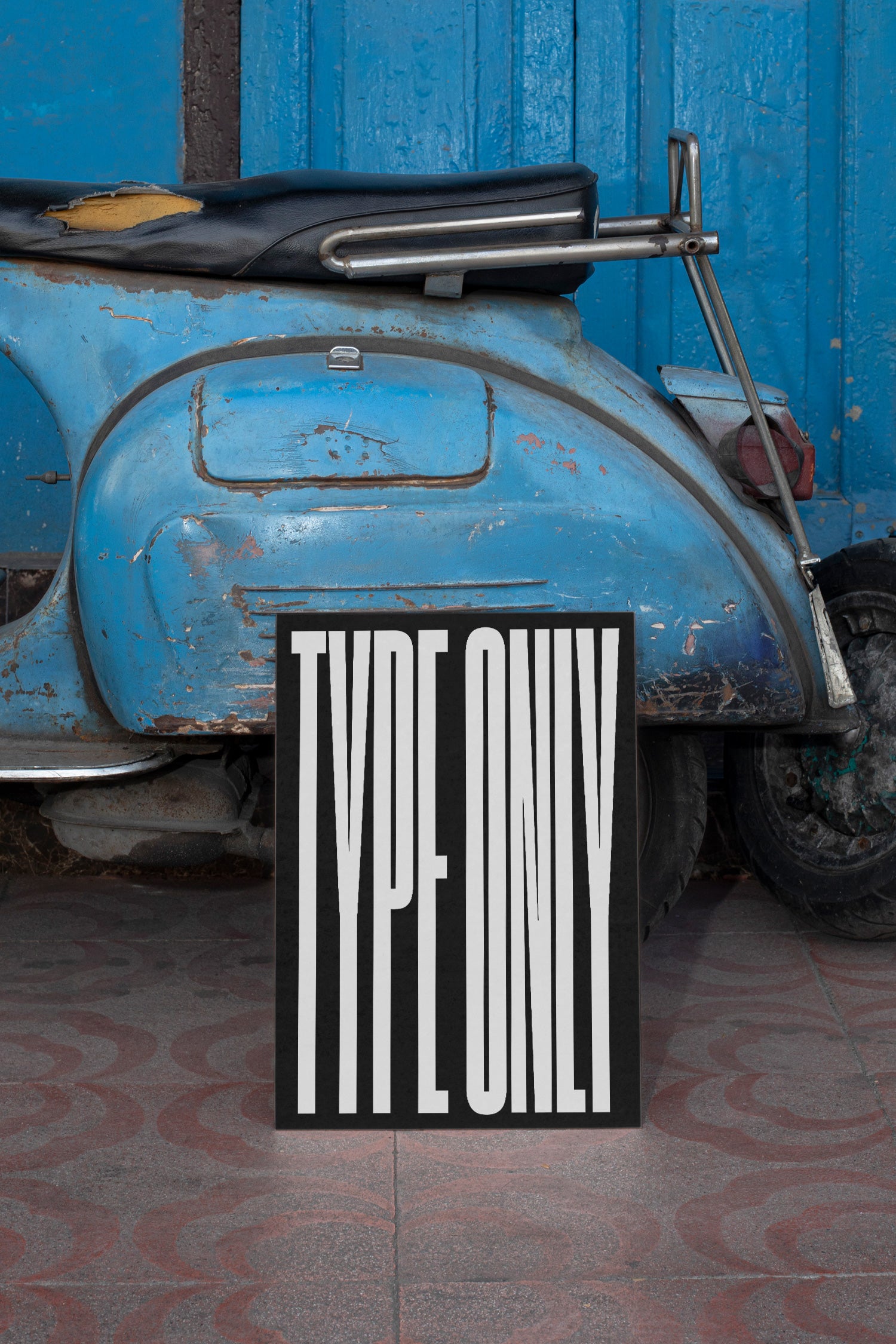 Poster mockup leaning against a vintage blue Vespa.