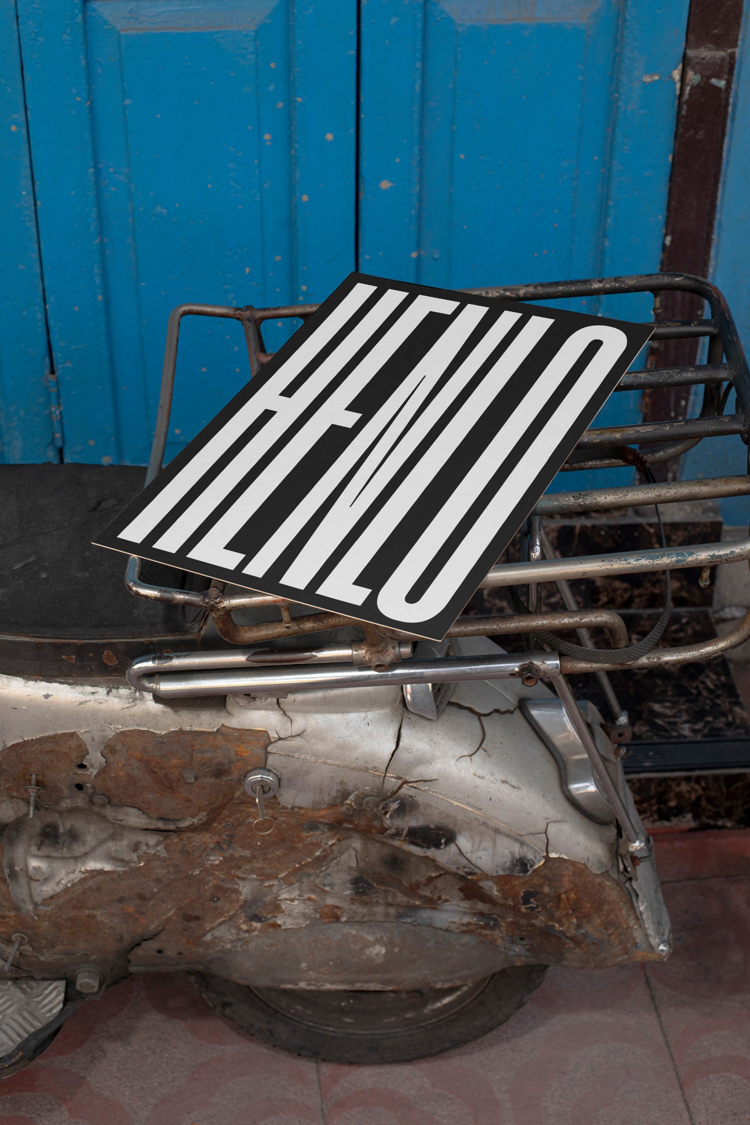 Poster mockup lying on the backpack of a vintage silver Vespa.