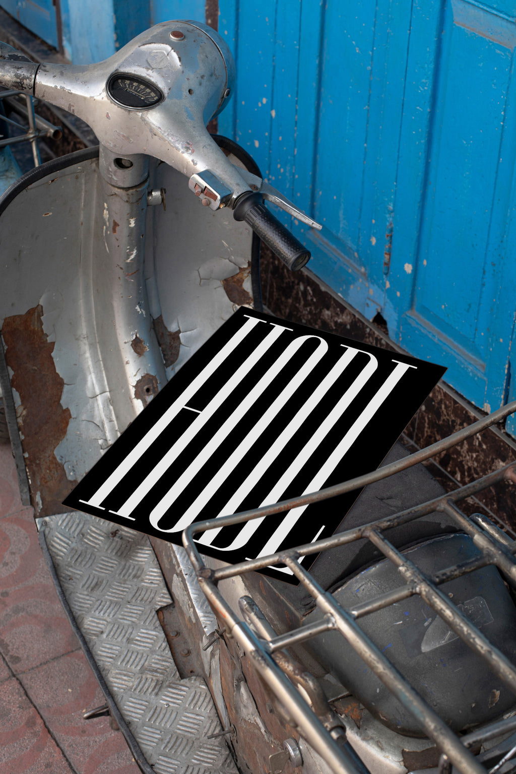 Poster mockup lying on the seat of a vintage silver Vespa.