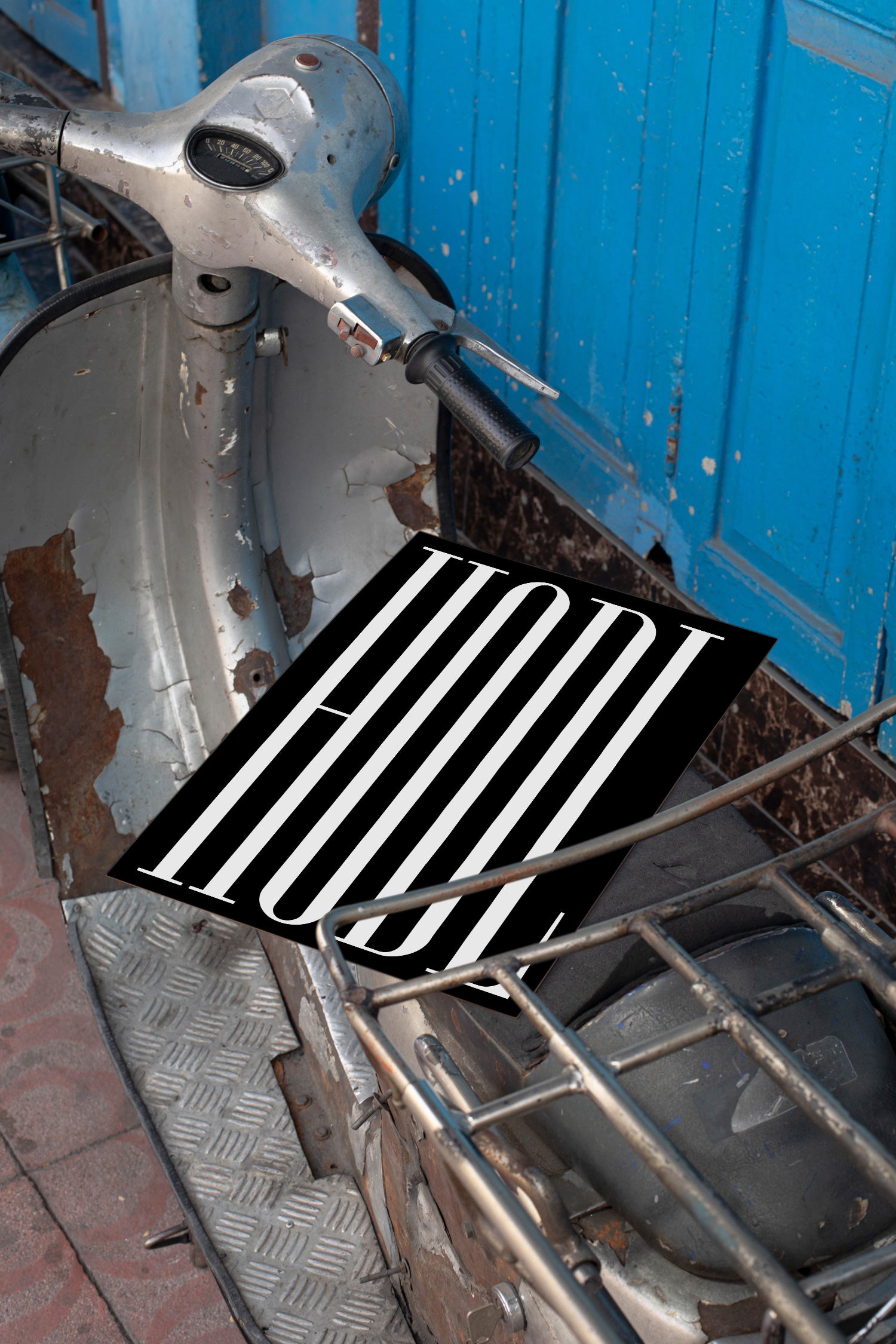 Poster mockup lying on the seat of a vintage silver Vespa.