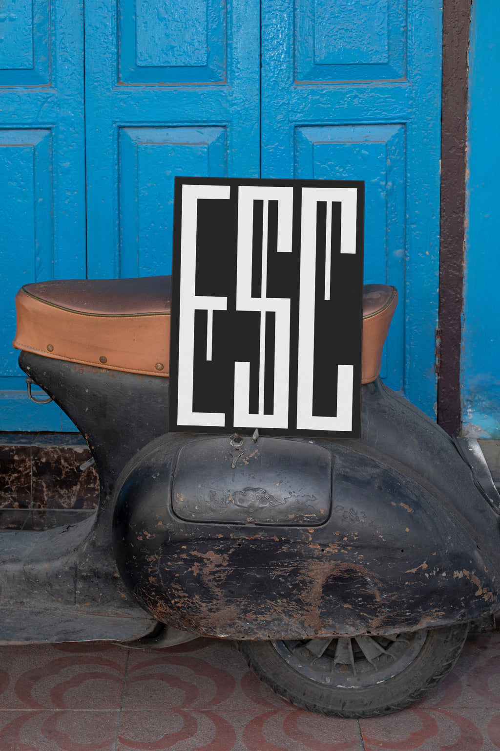 Poster mockup leaning against a vintage black Vespa.