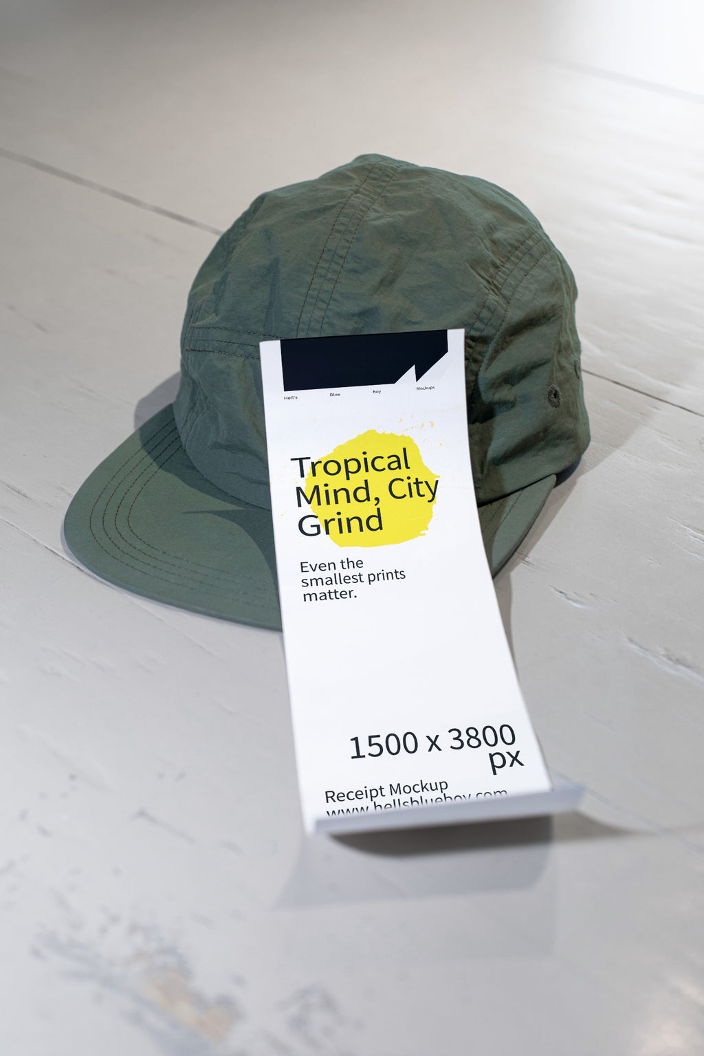 Cashier receipt mockup placed on a white wooden table with a green cap.