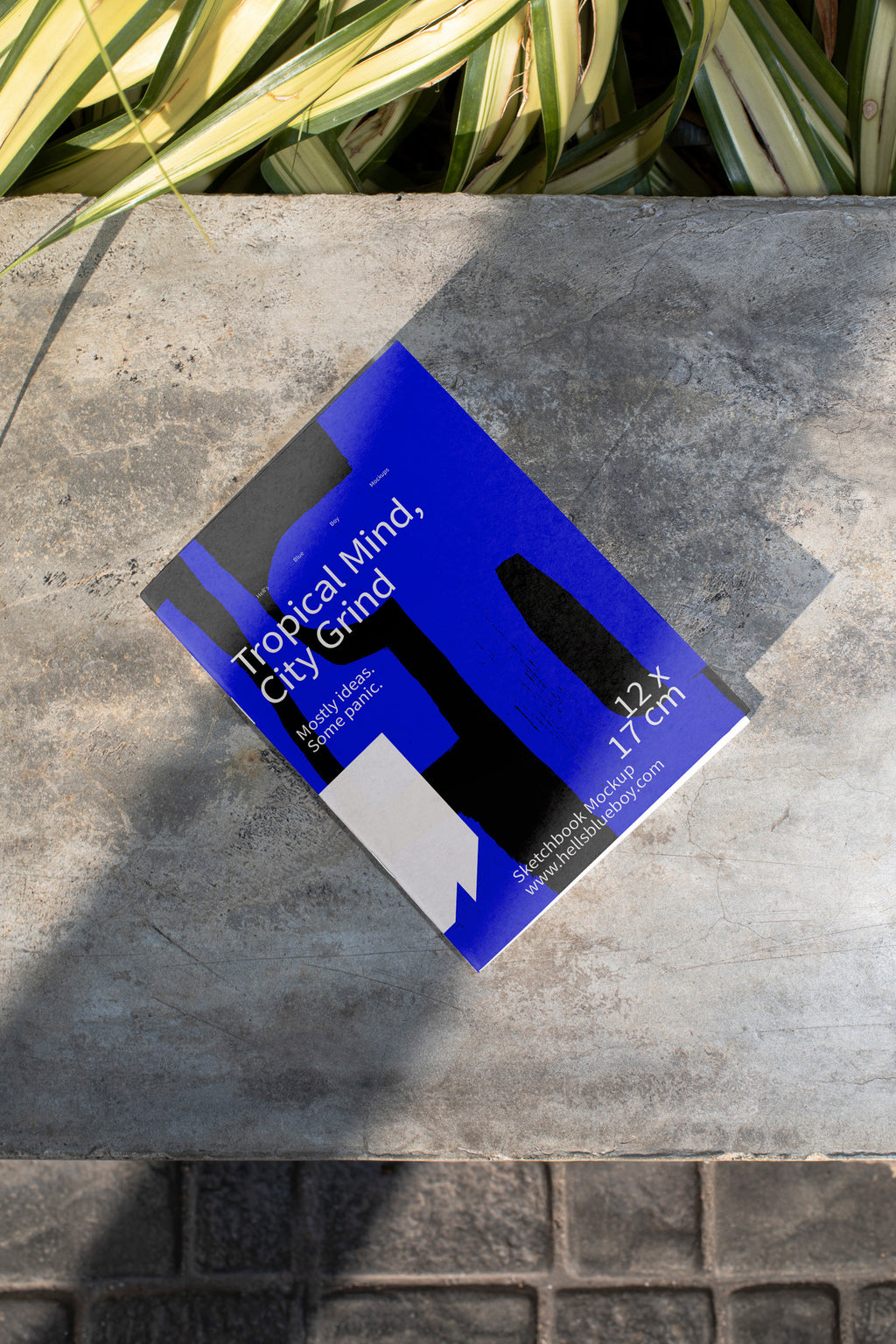 High-resolution sketchbook mockup placed on a concrete bench.