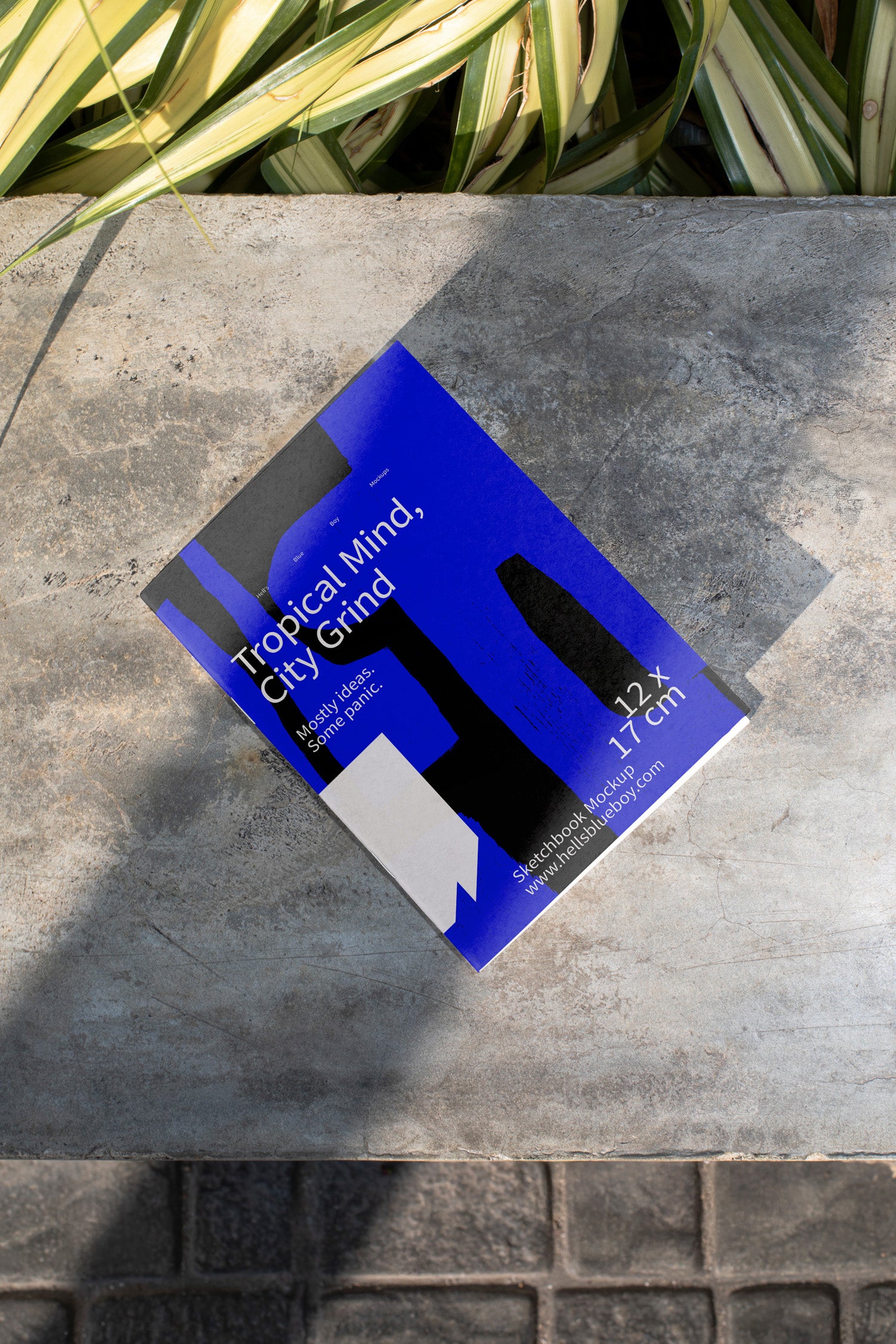High-resolution sketchbook mockup placed on a concrete bench.