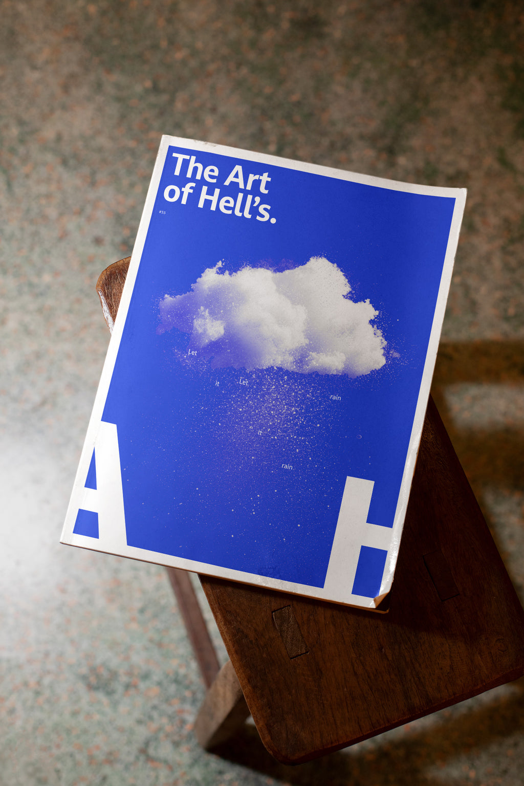 Softcover magazine mockup placed on a wooden stool.