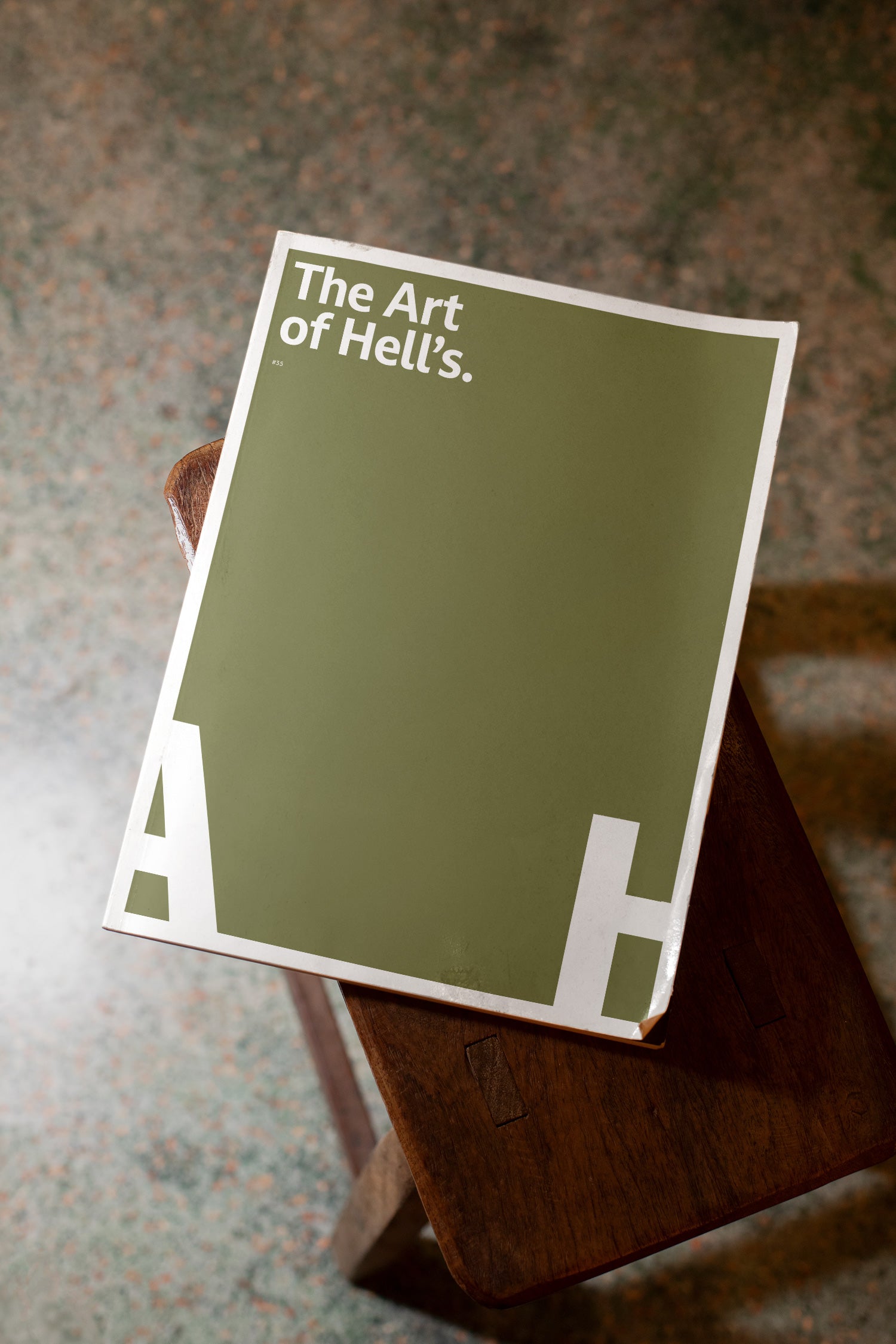 Softcover magazine mockup placed on a wooden stool.