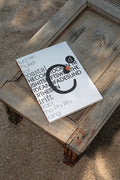 Softcover magazine mockup resting on a wooden table at the beach. Built for showcasing editorial layouts, magazine covers, branding, photography, and print concepts.