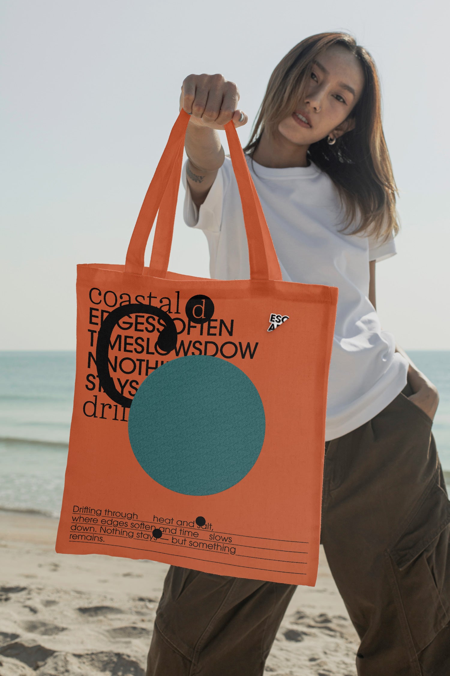 Tote bag mockup held by hand at the beach. Built for showcasing apparel brands, merchandise, fashion graphics, lifestyle branding, and retail concepts.