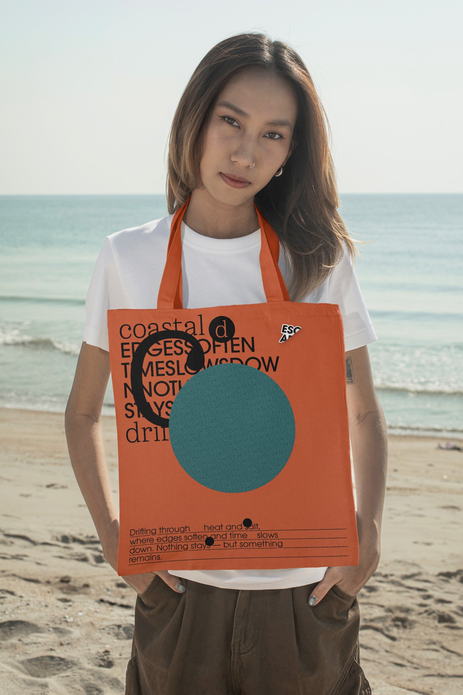 Tote bag mockup styled around the neck at the beach. Designed for presenting fashion brands, merchandise, lifestyle identities, and retail collections.