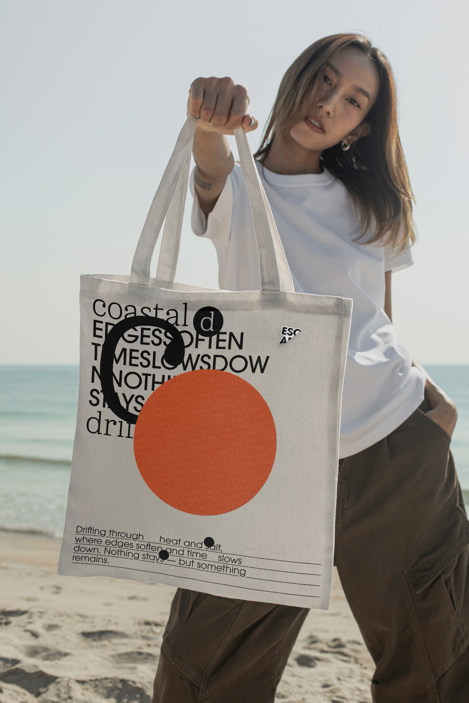 Tote bag mockup held by hand at the beach. Built for showcasing apparel brands, merchandise, fashion graphics, lifestyle branding, and retail concepts.