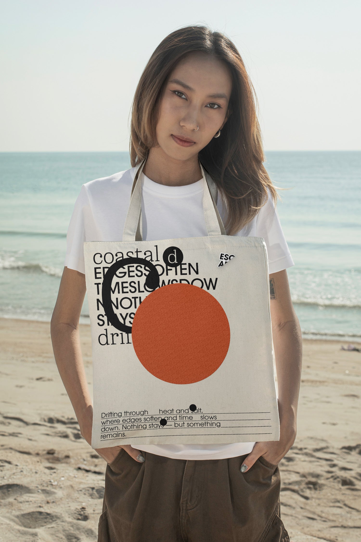 Tote bag mockup styled around the neck at the beach. Designed for presenting fashion brands, merchandise, lifestyle identities, and retail collections.