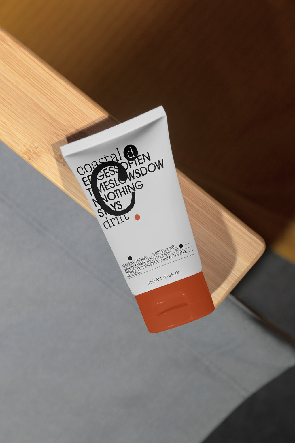 Sunscreen tube mockup resting on the wooden armrest of a beach chair. Built for showcasing cosmetic packaging, skincare brands, wellness products, and lifestyle concepts.
