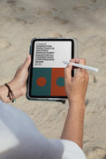 iPad mockup held by hand with pen against a sandy beach backdrop in Hua Hin, Thailand. Built for showcasing app interfaces, branding, editorial layouts, illustrations, and creative presentations.