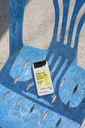 iPhone mockup lying on a blue plastic chair with strong shadows. Ideal for showcasing app screens, UI design, and mobile branding visuals.